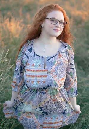 Hot redhead BBW Kaycee looses her huge tits and gets on her knees in a field