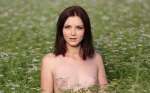 Beautiful brunette strips naked to spread ass in a field of daisies