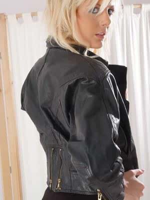 Blonde model flashes a naked breast in a black leather jacket