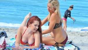 Lesbian girls in bikini kissing tonguing  showing hot ass at the beach