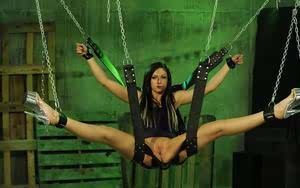 Brunette female is threatened with wax while suspended in a bondage swing