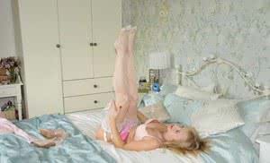 Older blond MILF Nylon Sue strutting on bed in panties stockings and lingerie