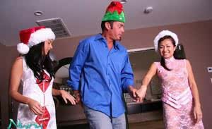 Fully clothed Asian female with crossed legs entertains man at Christmas time