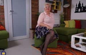 Fat grandmother strips down to black stockings before fingering her vagina